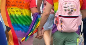 two men wearing rainbow t-shirts holding hands at Cincinnati Pride Parade