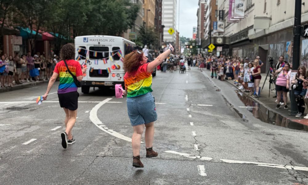 A woman skipping through the street at Pride Parade