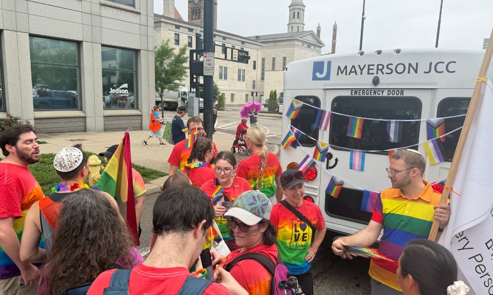 A group of 10 people speaking to each other before the start of the Pride Parade
