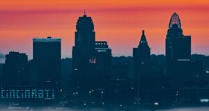 High Rise Buildings in shadow framed by a orange, yellow, and red sky at dusk
